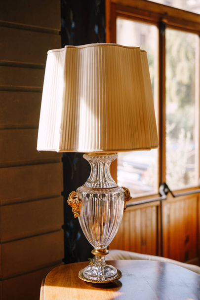 Lámpara de mesa antigua vintage con pantalla blanca y base de cristal
 - Foto, Imagen