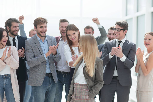 corporate group of employees applauding a young colleague - 写真・画像