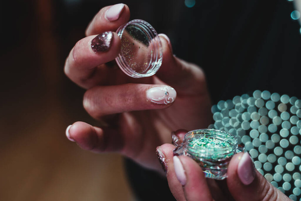 young woman opening glitter box for nail art - Fotó, kép
