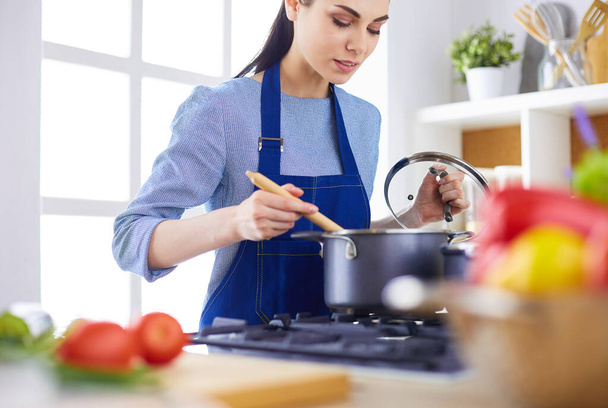 Cooking woman in kitchen with wooden spoon - Foto, Imagem