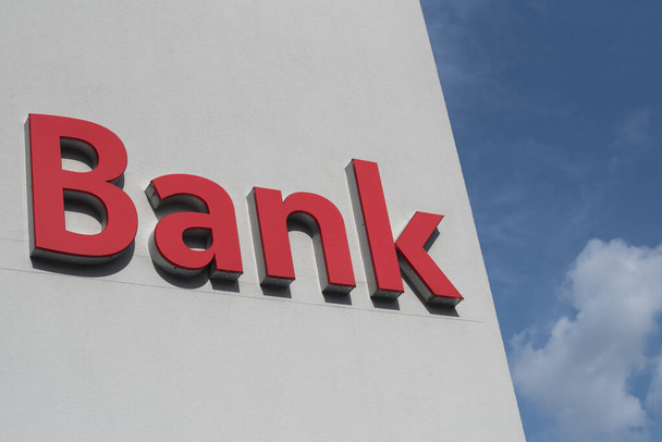 Czerwony podpis banku na białym tle, finanse i instytucja kredytowa - Zdjęcie, obraz