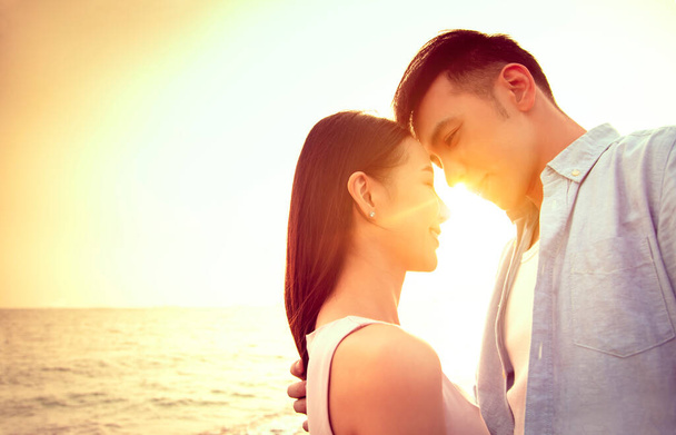 kochająca azjatycka młoda para całująca się o zachodzie słońca. Walentynki. - Zdjęcie, obraz