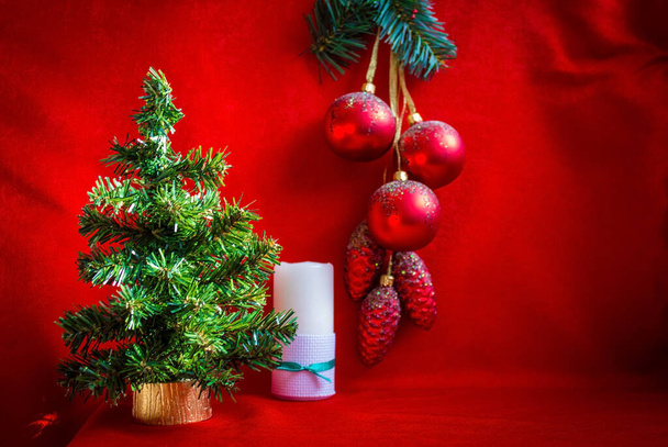 Noel ağacından yeni yıl kompozisyonu, dekorasyon ve mumlar. Kırmızı doymuş arka plan. Yan ışıklandırma, vignet. - Fotoğraf, Görsel