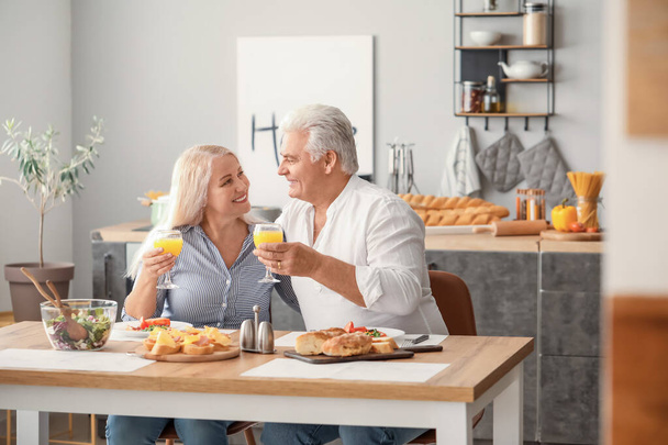 Boldog idős házaspár otthon reggelizik - Fotó, kép