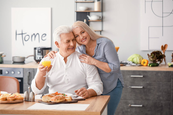Ευτυχισμένο ηλικιωμένο ζευγάρι που τρώει πρωινό στο σπίτι - Φωτογραφία, εικόνα