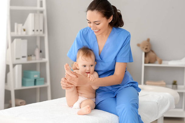 Μασάζ θεραπευτής που εργάζονται με χαριτωμένο μωρό στο ιατρικό κέντρο - Φωτογραφία, εικόνα