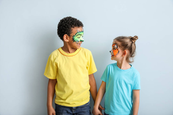 Funny children with face painting on color background - Foto, Imagen