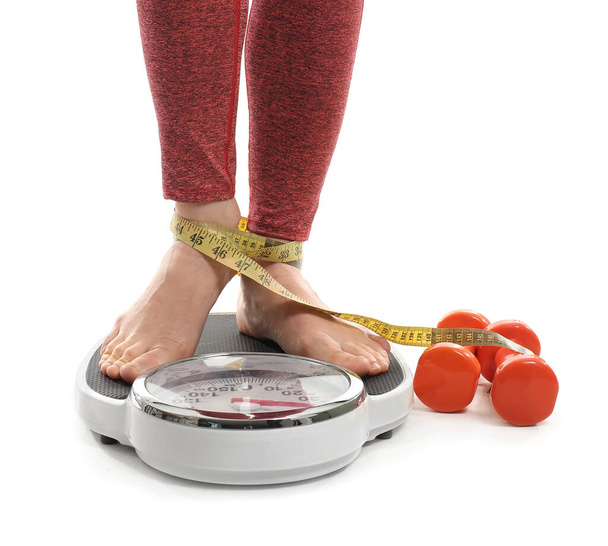 Mladá žena měření její váhy na bílém pozadí - Fotografie, Obrázek