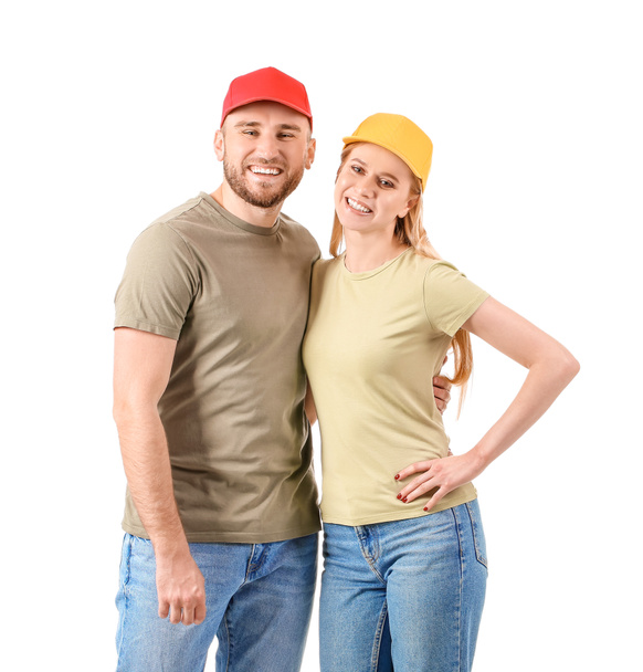 Young couple in stylish caps on white background - 写真・画像