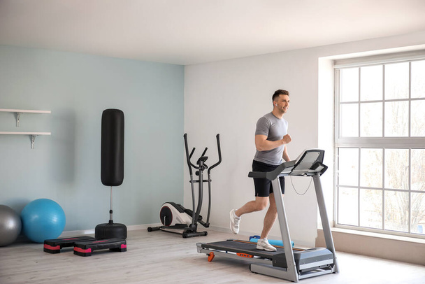 Young man training on treadmill in gym - Photo, Image