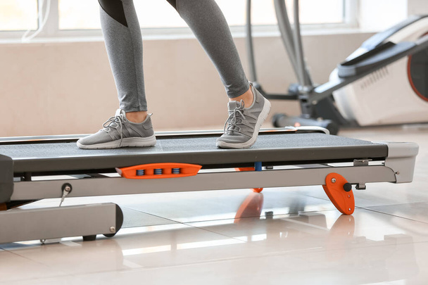 Sportif jeune femme formation sur tapis roulant dans la salle de gym
 - Photo, image