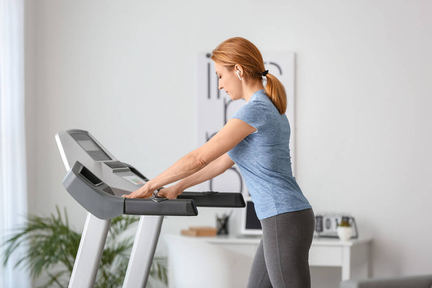 Sporty woman training on treadmill at home - Foto, Imagem