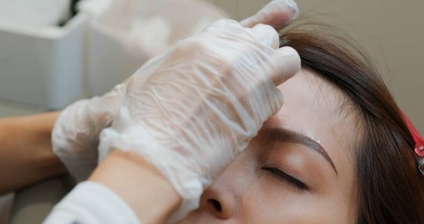 Kosmetikerin Spezialist für Permanent Make-up macht Stirn Microblading Tätowierung Make-up - Foto, Bild