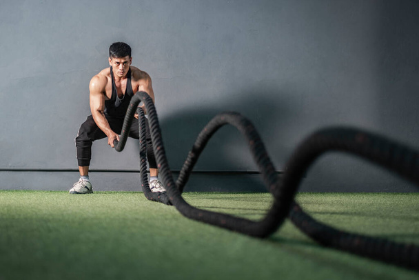 筋力トレーニングフィットネスジムでロープ付きの強力な筋肉マンワークアウト - 写真・画像