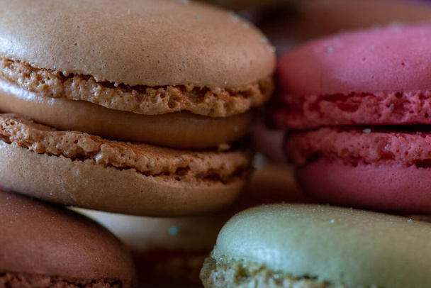 Colorful macarons on black background, close up view - Foto, imagen