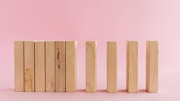 Juguetes de madera dispuestos en una fila horizontal sobre fondo rosa para actividades de ocio concepto
 - Foto, imagen