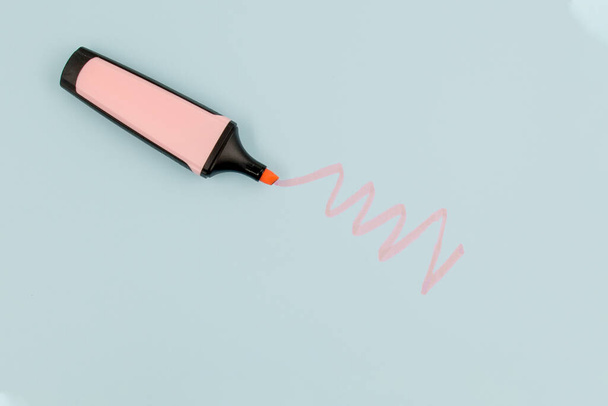 Pink highlighter draws doodle on a blue paper with copy space - Photo, Image