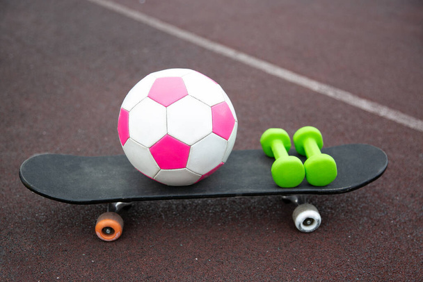 pink soccer ball, dumbbells, skateboard isolated on the treadmill. The concept of sports lifestyle. - Fotoğraf, Görsel