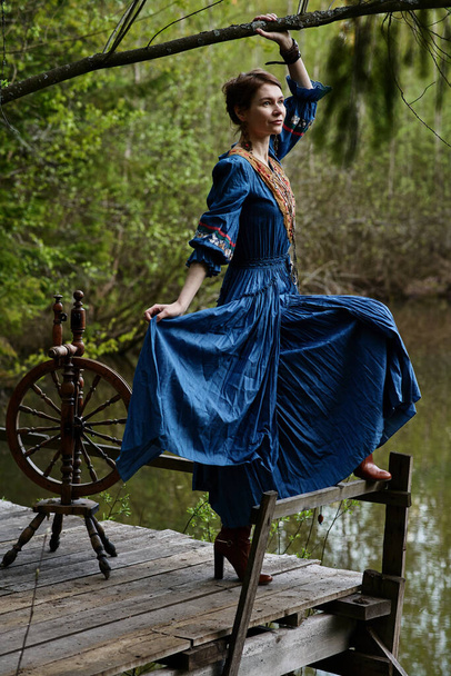 Pretty girl in long dress at the deep dark forest - Fotografie, Obrázek