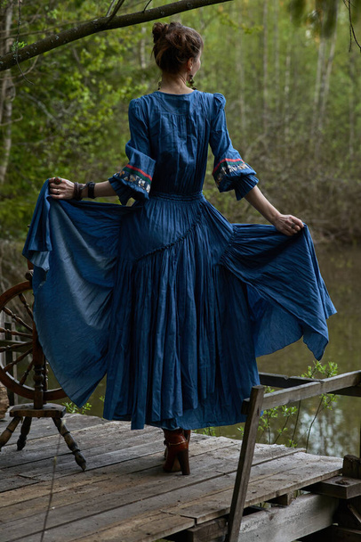 Pretty girl in long dress at the deep dark forest - Фото, зображення