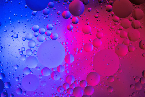 Gotas de aceite sobre la superficie del agua color fondo abstracto. círculos azules y rosados
  - Foto, Imagen