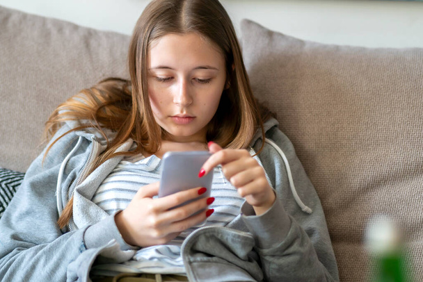 Gelangweilte Teenager blicken auf ihr Handy. Selektiver Fokus - Foto, Bild