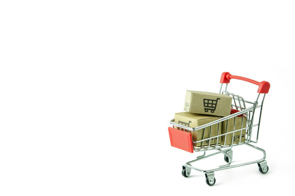 Concepto de compra: Cartones o cajas de papel en rojo carro de la compra sobre fondo blanco. los consumidores de compras en línea pueden comprar desde el hogar y el servicio de entrega. con espacio de copia
 - Foto, Imagen