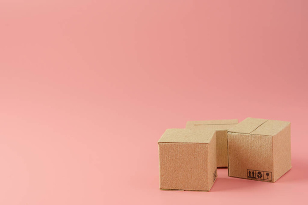 Concetto di shopping: cartoni o scatole di carta su sfondo rosa. i consumatori di shopping online possono fare acquisti da casa e il servizio di consegna. con spazio di copia - Foto, immagini