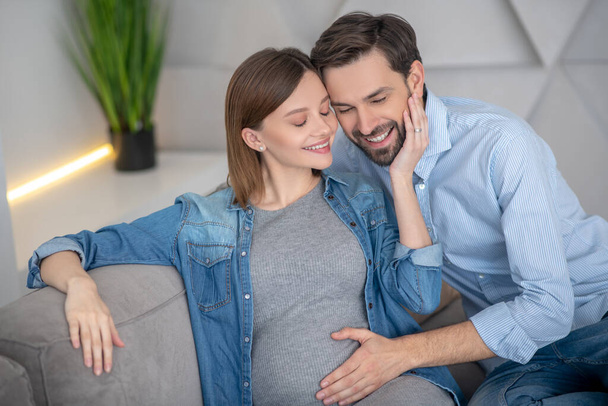 Young pregnant woman feeling happy with her husband - Фото, изображение