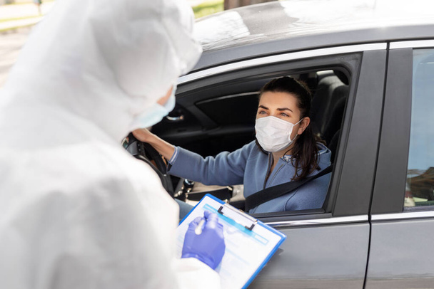healthcare worker with clipboard and woman in car - Фото, зображення