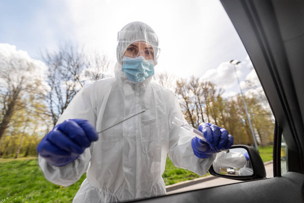 healthcare worker making coronavirus test at car - Zdjęcie, obraz