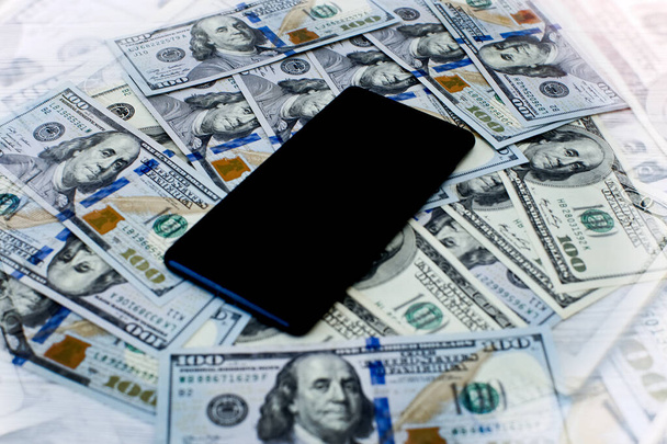 The phone is on the money . Money investment via phone, mobile payments. Phone in dollars . - Fotoğraf, Görsel