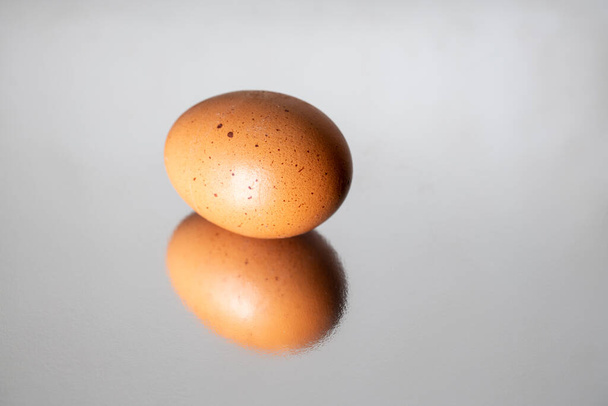 Egg with harsh shadows reflected and isolated - Foto, afbeelding