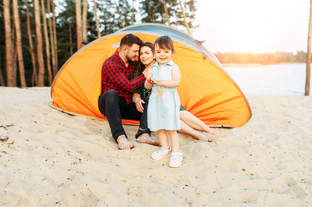 Young family spend time together in a forest camp - 写真・画像