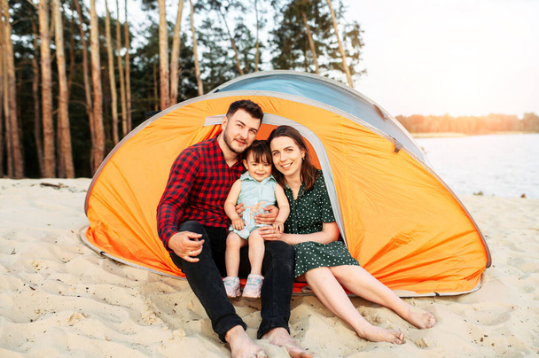 Young family spend time together in a forest camp - Foto, afbeelding