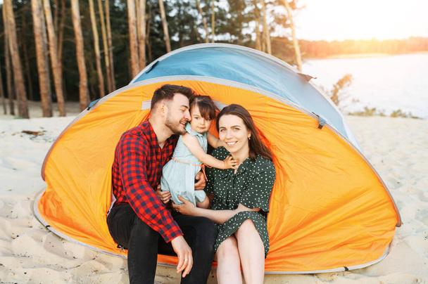 Young family spend time together in a forest camp - Foto, Bild
