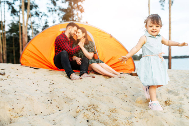 Nuori perhe viettää aikaa yhdessä metsäleirillä
 - Valokuva, kuva