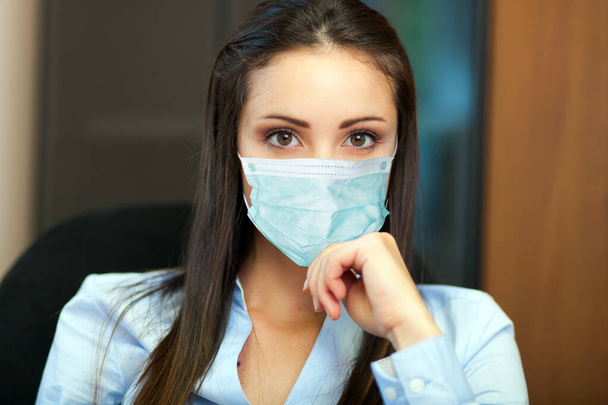 Young female manager wearing a mask, coronavirus concept - Фото, изображение