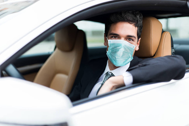 Handsome man driving his car wearing a mask, coronavirus concept - Foto, Imagem