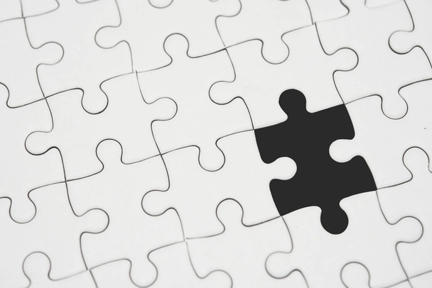 White jigsaw puzzle pattern background. placing last piece of jigsaw puzzle - 写真・画像