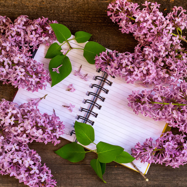 A bunch of pink lilac on a white notebook. - 写真・画像