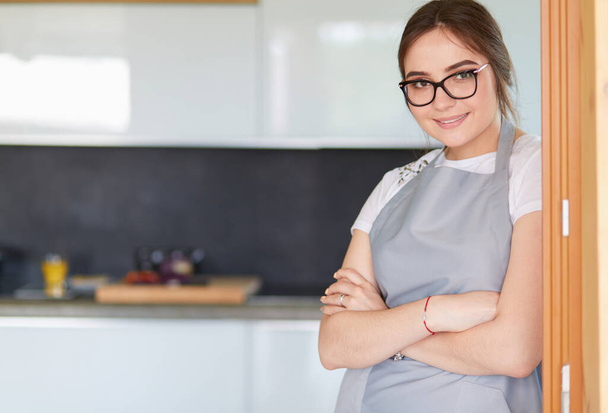 Young woman standing near desk in the kitchen - Photo, Image