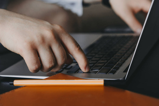 Close up of a mans hand typing on a laptop - Zdjęcie, obraz