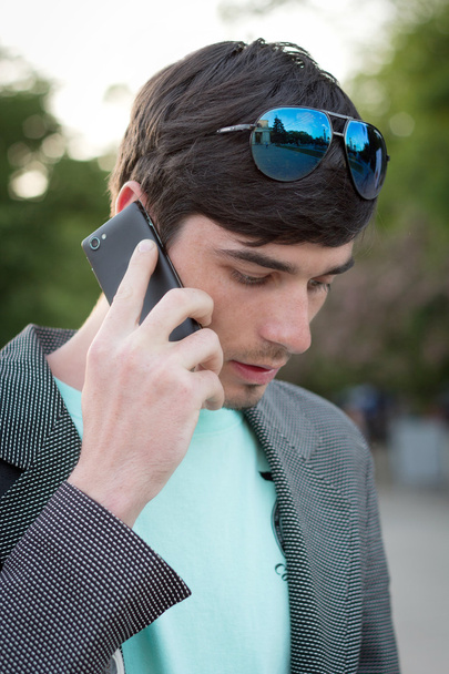 çekici genç adam açık havada telefonla aramalar - Fotoğraf, Görsel