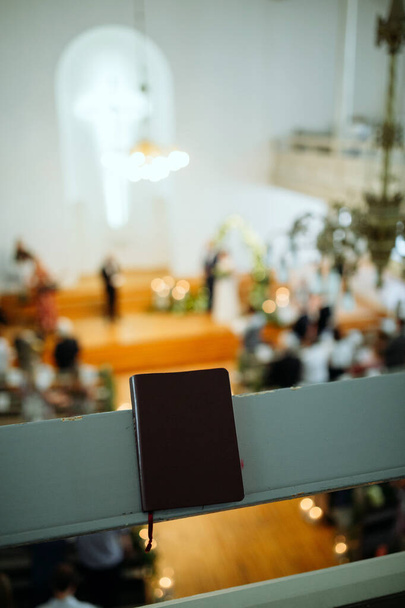 Details of the wedding day. Church and Bible during the wedding ceremony. Fine film grain texture. - Photo, Image