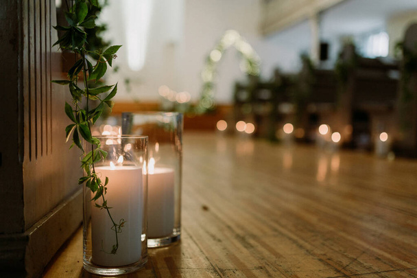 Details zum Hochzeitstag. Kirchliche Hochzeitsdekoration mit Pflanzen und Kerzen. Feinkörnige Textur. - Foto, Bild