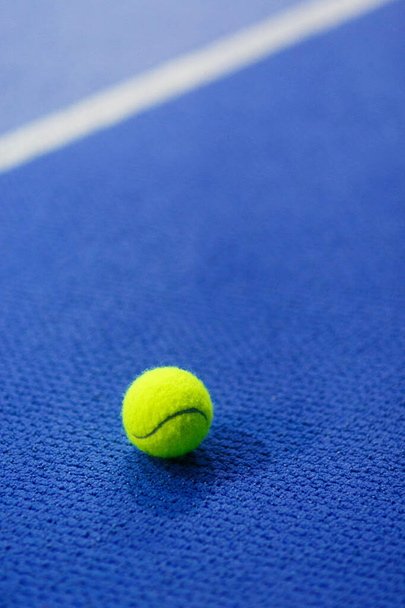 Palla da tennis gialla su tappeto interno blu brillante
 - Foto, immagini