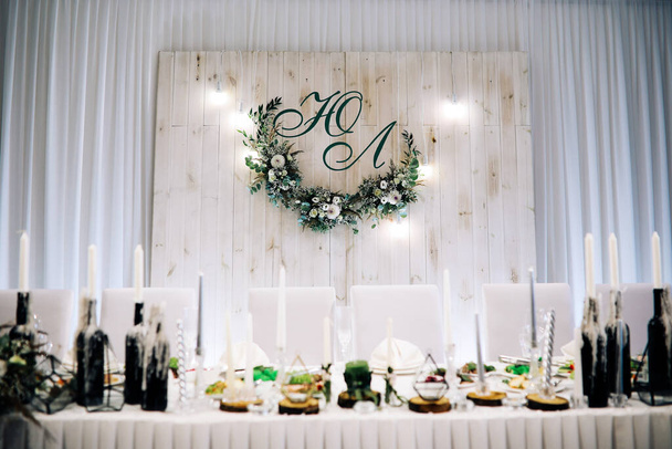 Rivne / Ukrajna - 09 / 21 / 2018 - Esküvői dekorációk. Dekoráció az esküvői terem élénk színekben zöld árnyalatú rusztikus stílus segítségével friss virágok. Egy asztal gyertyákkal a gyertyatartón, háromszögletű figurákkal. - Fotó, kép