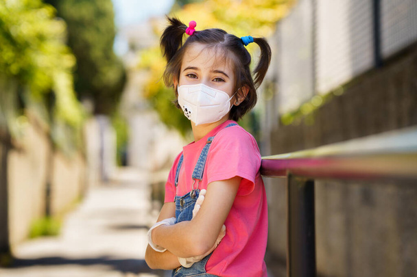 Mädchen mit Schutzmaske gegen Coronavirus während der Covid-19-Pandemie - Foto, Bild