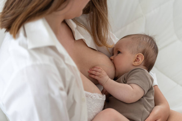 Mother breastfeeding her 3 months old baby girl - Fotó, kép